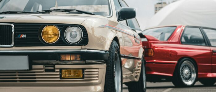 Classic BMW cars are parked outdoors.