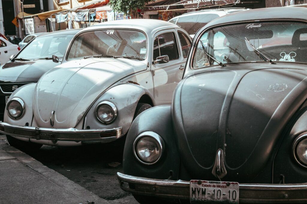 a row of old cars parked on the side of the road