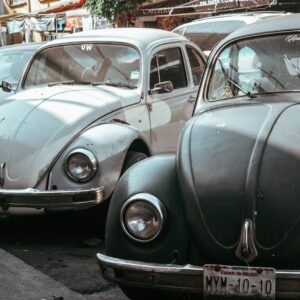a row of old cars parked on the side of the road