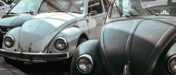 a row of old cars parked on the side of the road