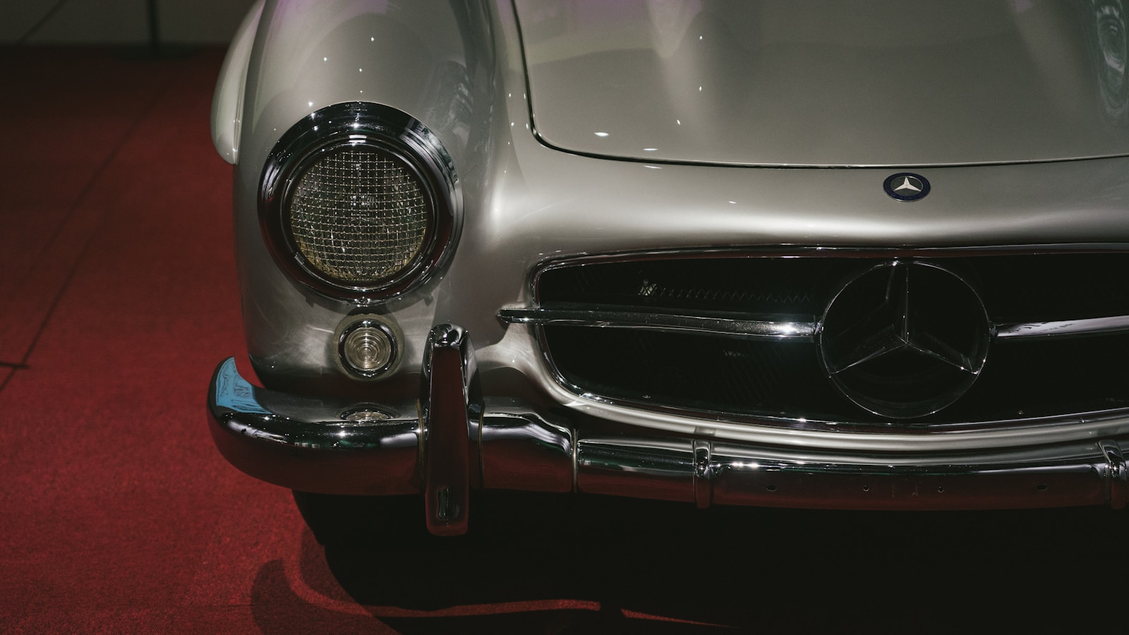 A silver mercedes sports car on display at a car show