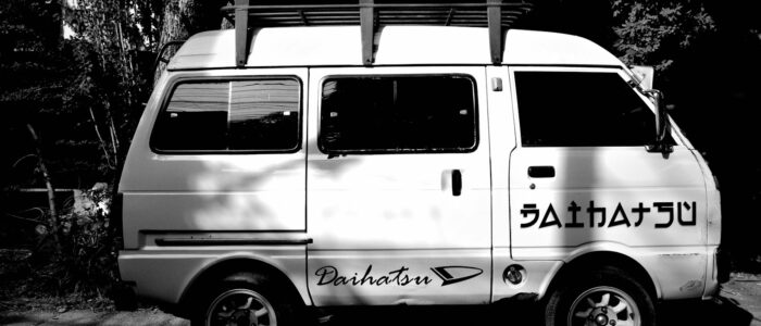 A small van parked outside on a sunny day.